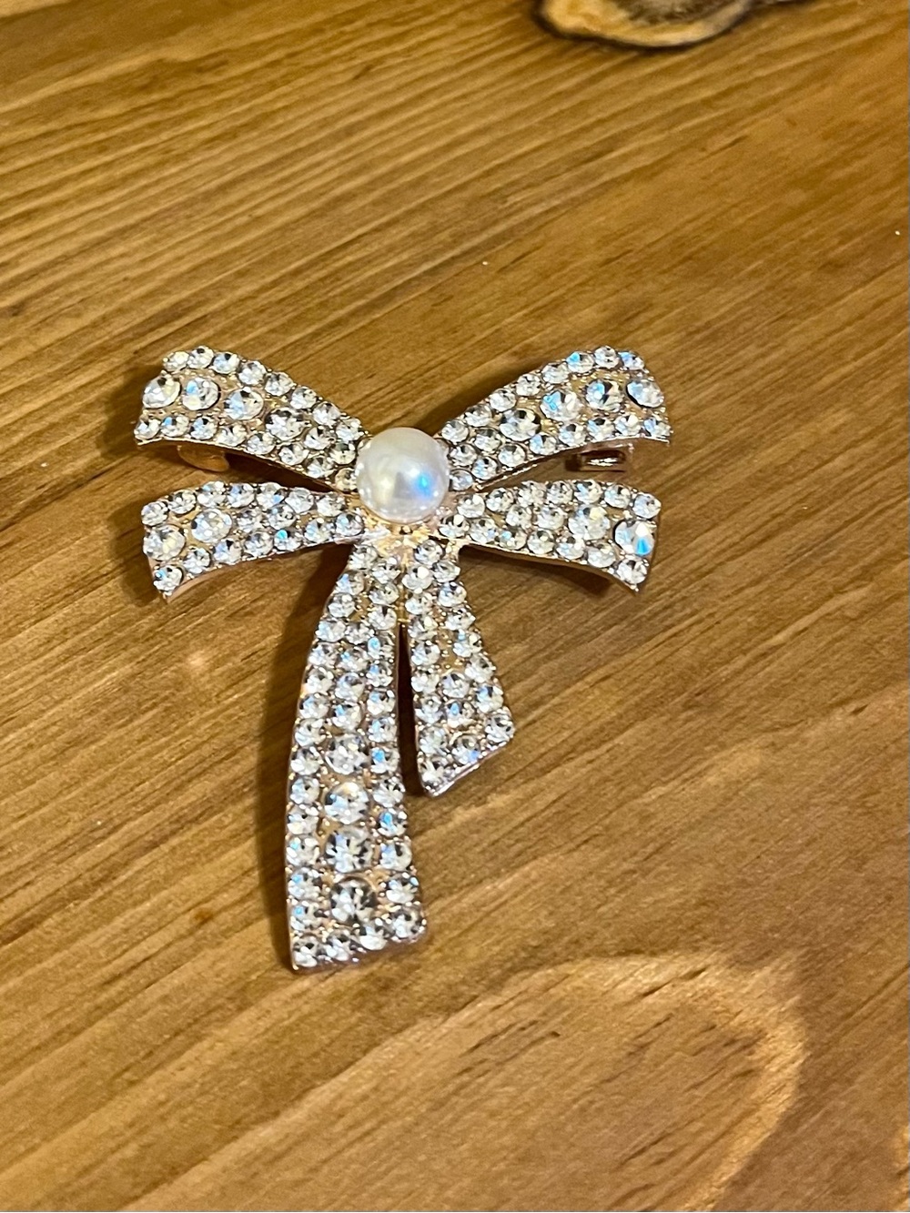 Bow brooch with clear rhinestones & pearl in center on gold tone 2 1/4”